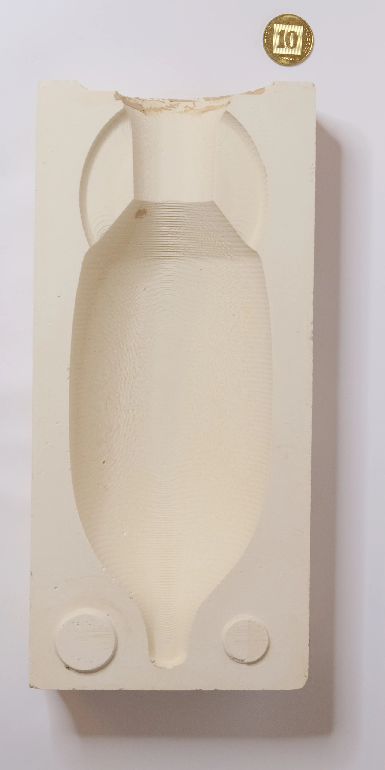 Large Amphora mold half with fine curved milling marks and a coin for scale