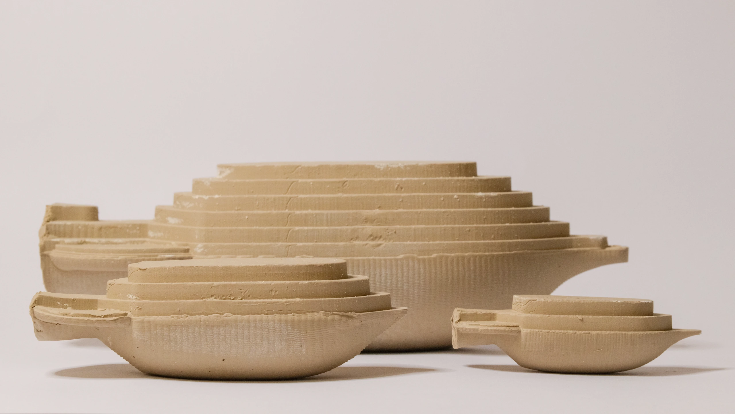 Three clay Amphora forms with stepped upper surfaces and curved undersides