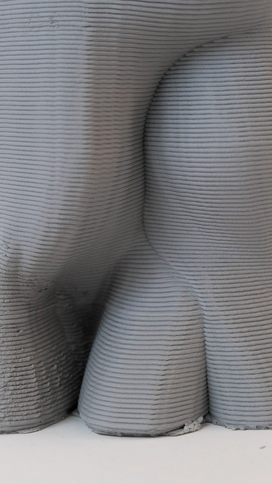 Close detail of the layered surface and overhangs of a printed clay form